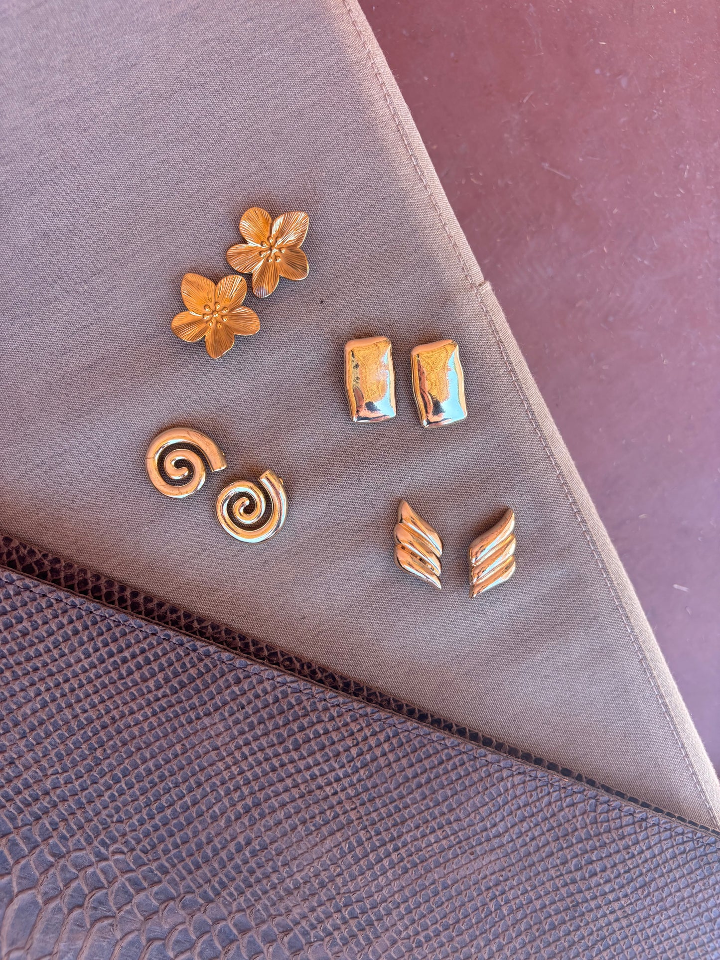 A collection of elegant earrings including Fleur Earrings by ÈRE; showcases their floral design as part of an attractive arrangement of flower statement earrings.