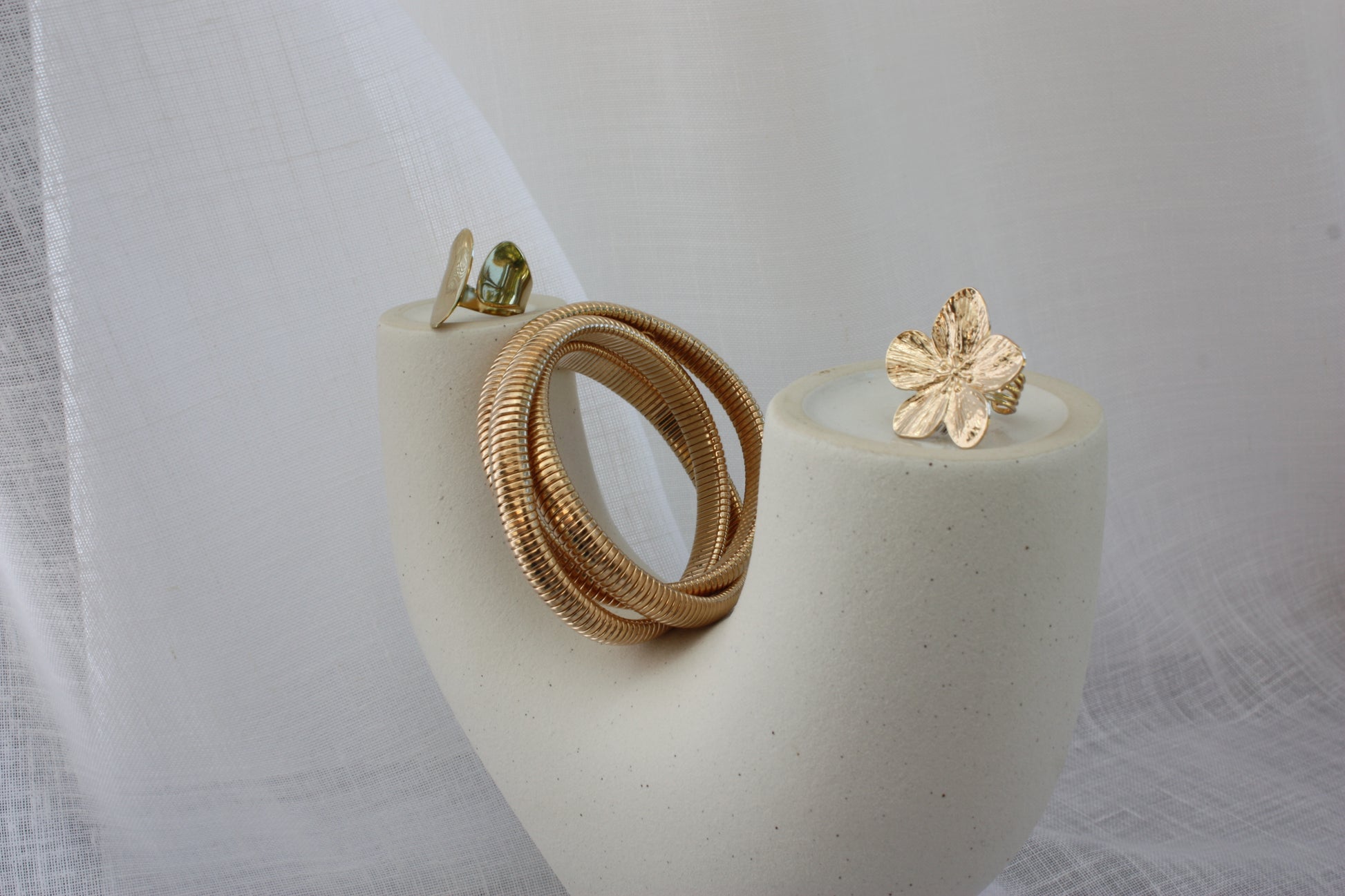 The Sloane Ring by ÈRE pictured with other jewellery pieces, featuring a minimalist aesthetic. This adjustable gold ring is a must-have for any stylish collection.